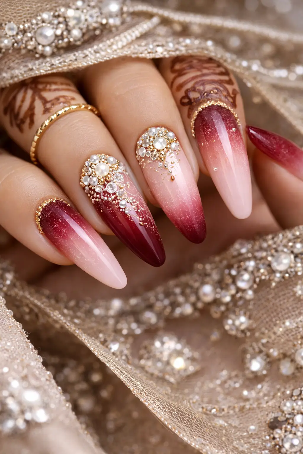 Maroon ombre bridal nails with pearl and gold detailing for wedding hands