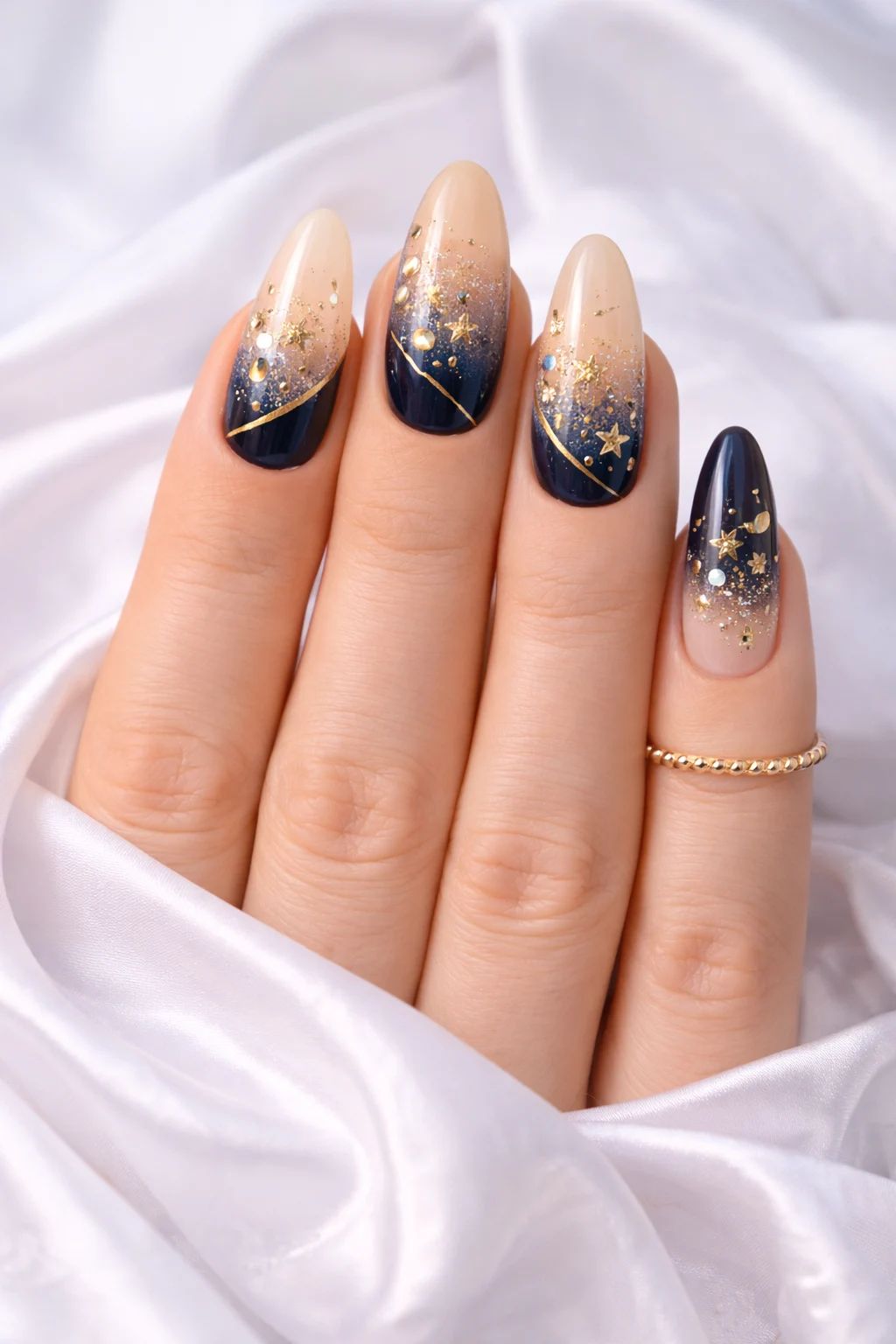 nude and navy ombre nail design with gold star details and glossy finish