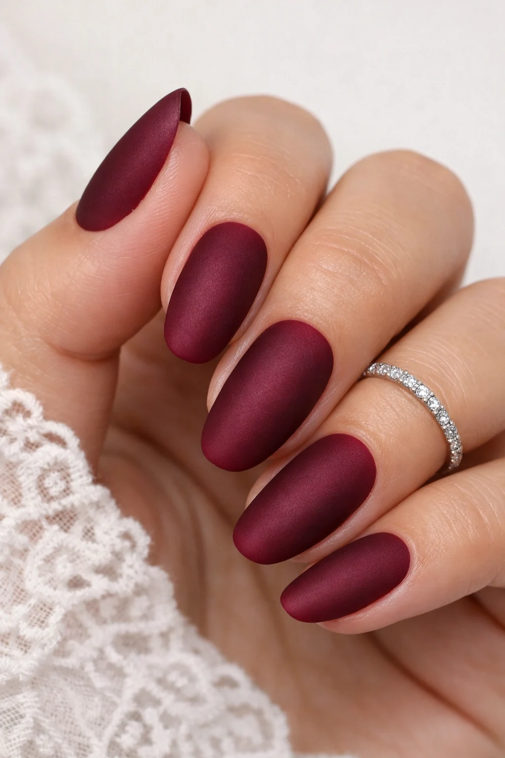 Matte burgundy bridal nails with velvet finish for an elegant wedding style