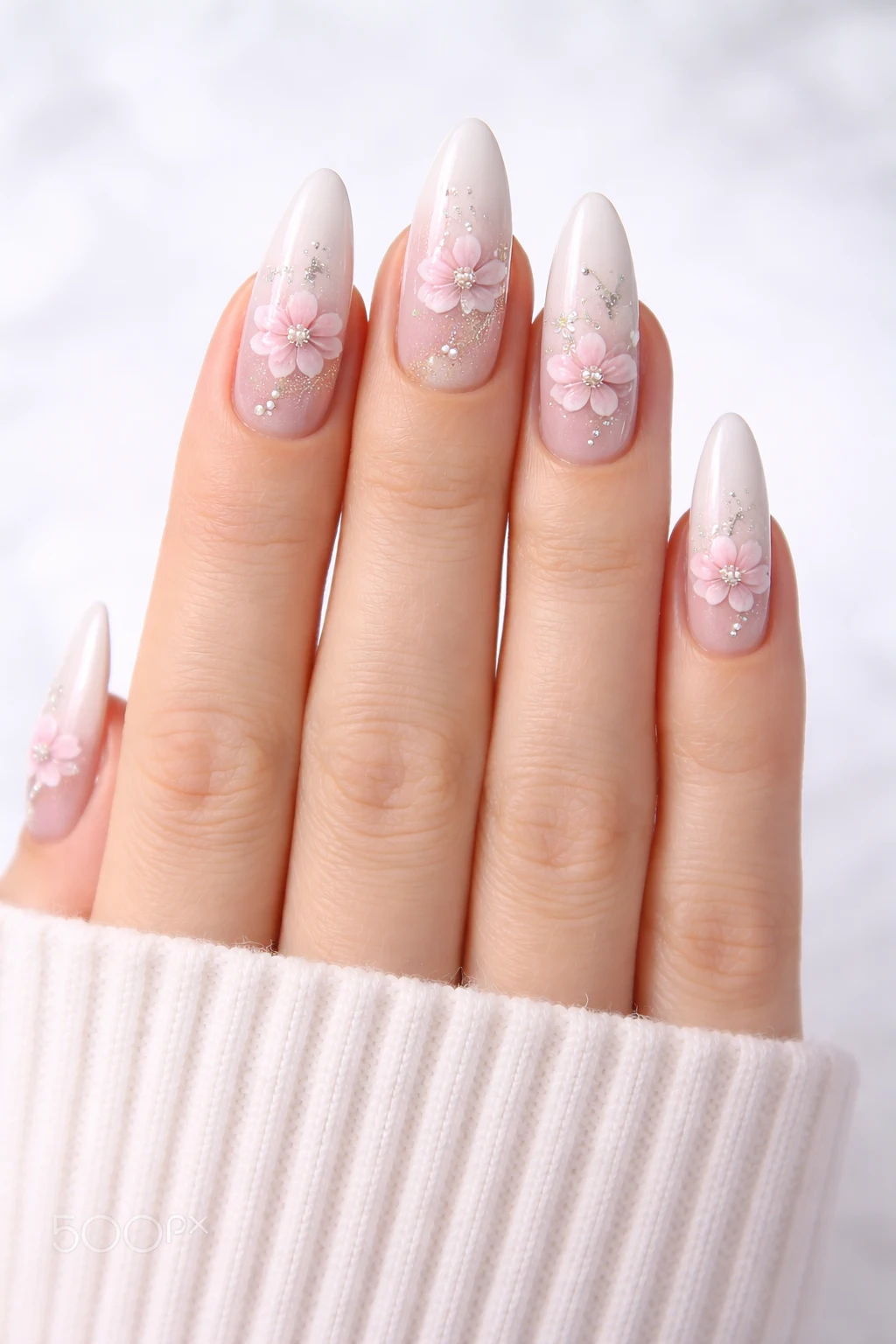 light nude floral nail design with pink flowers and pearl details