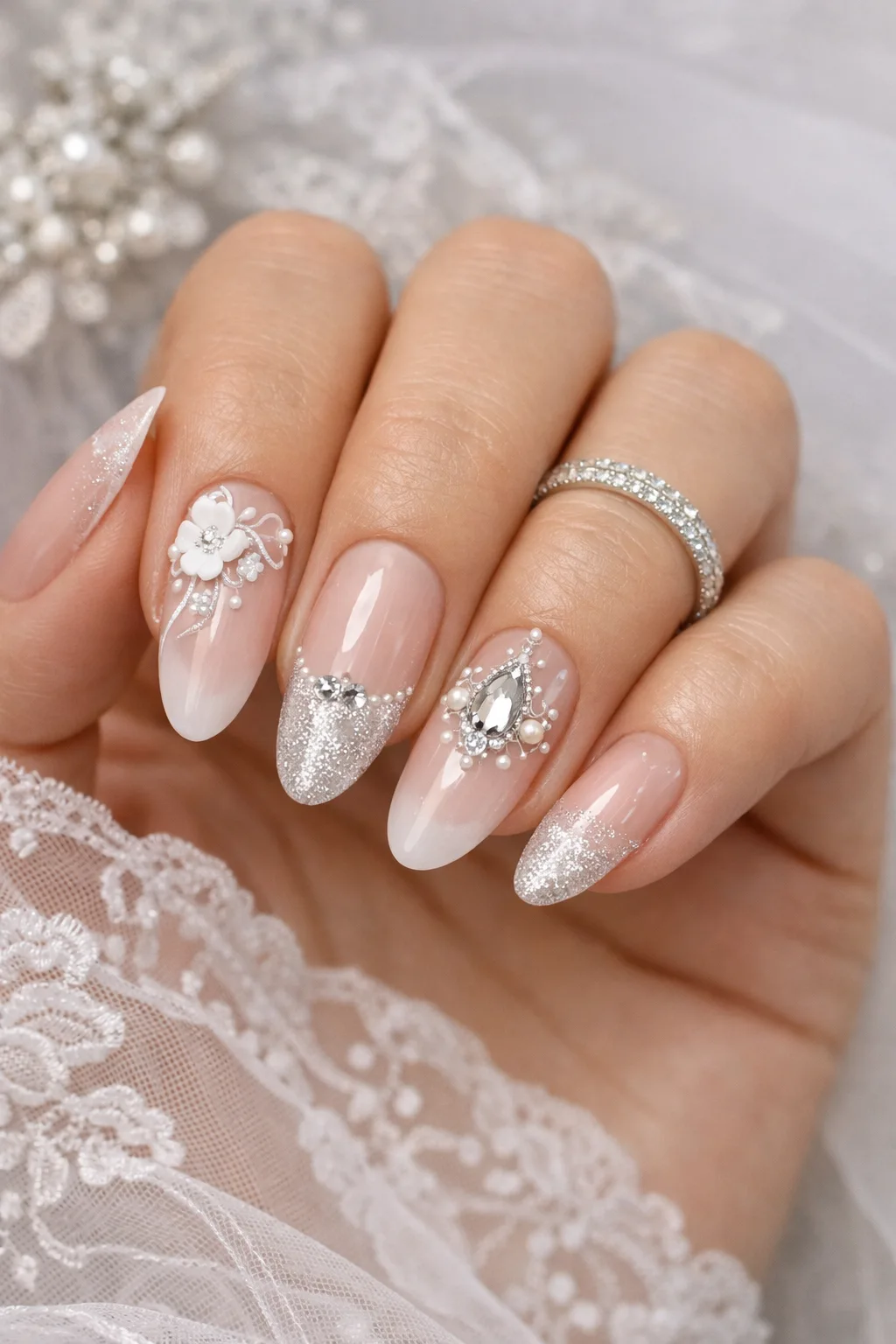Milky nude bridal nails with silver glitter and floral artwork for weddings