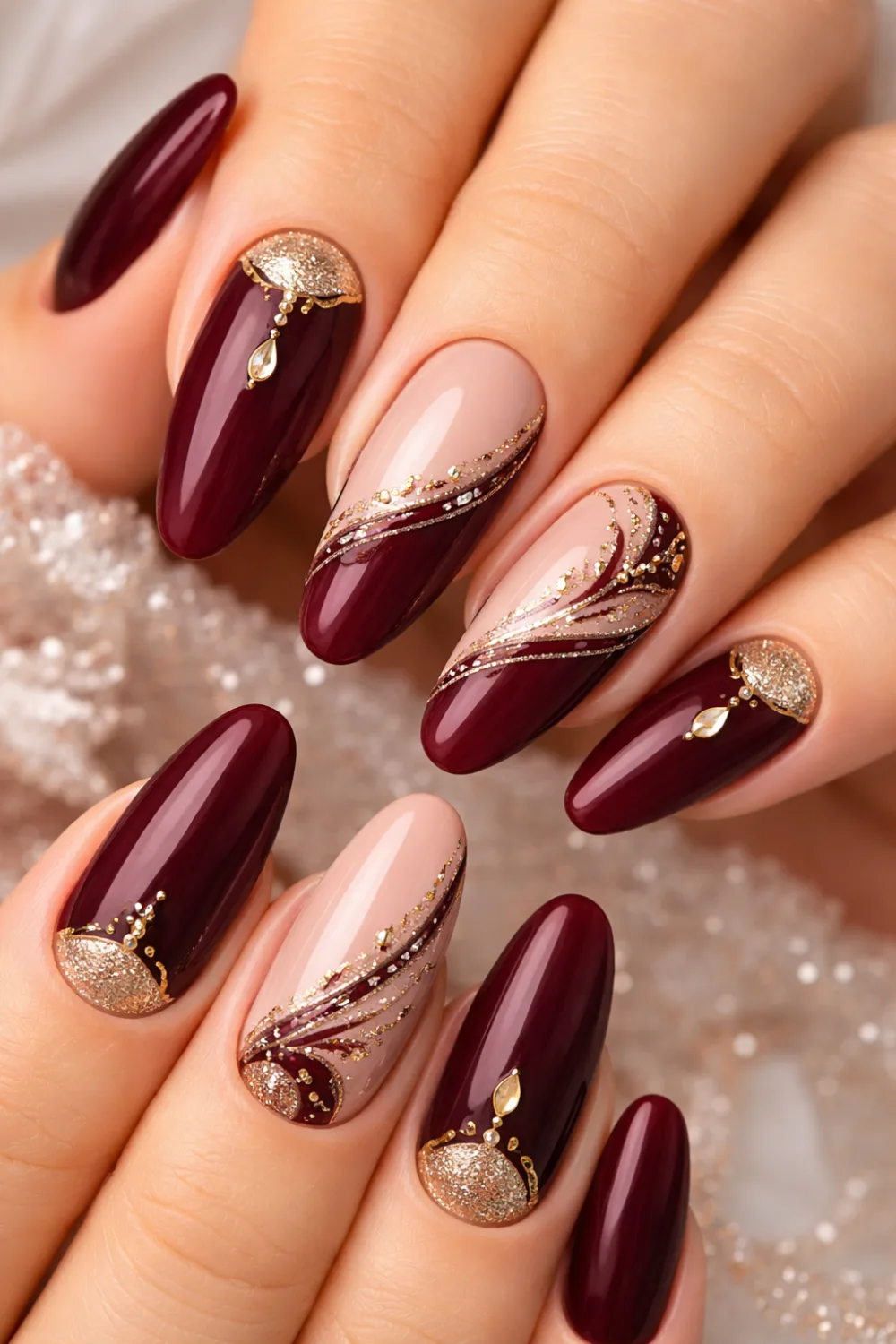 royal maroon glitter gel nails for eid, glossy burgundy manicure with gold and crystal accents, statement festive nails