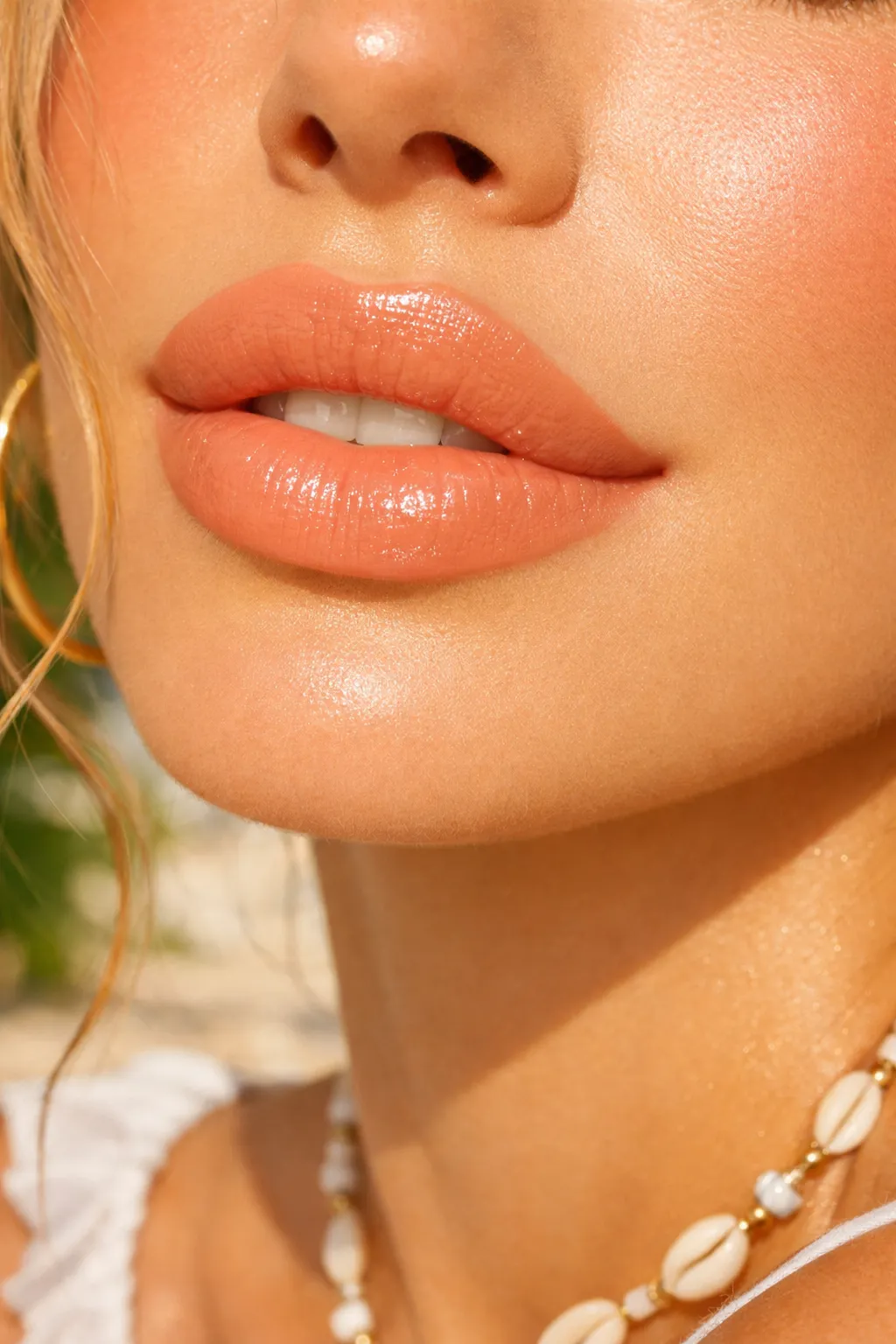 glossy peach nude lipstick with warm summer glow on light skin close up lips