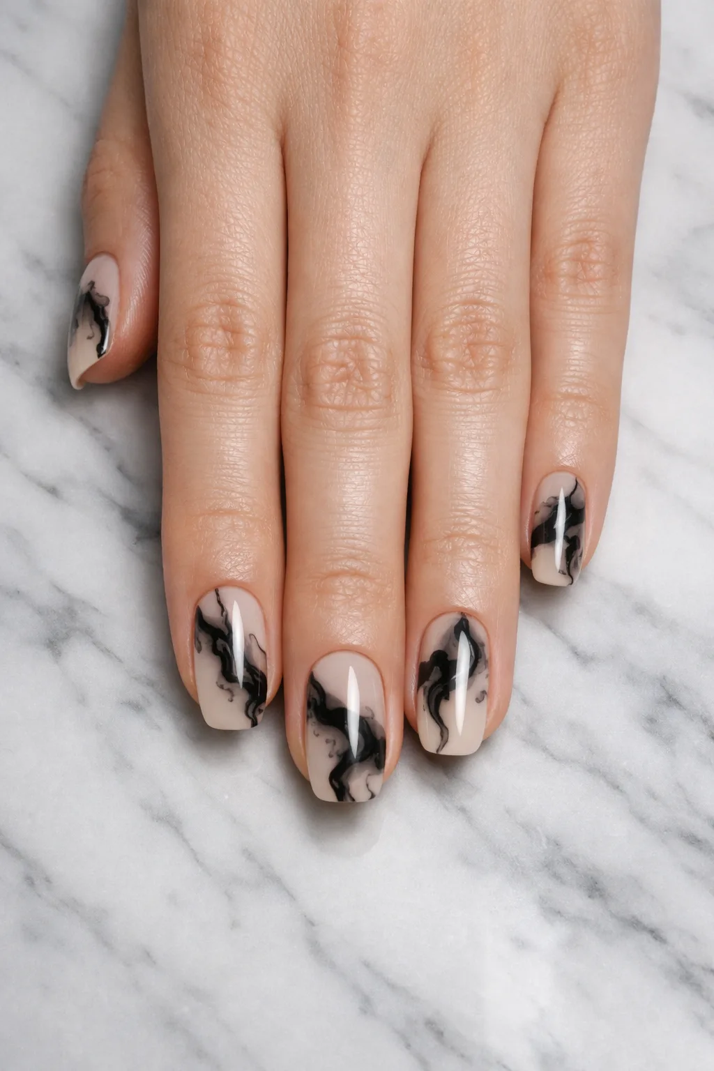 Black ink swirl blooming gel nail art on nude base modern marble manicure