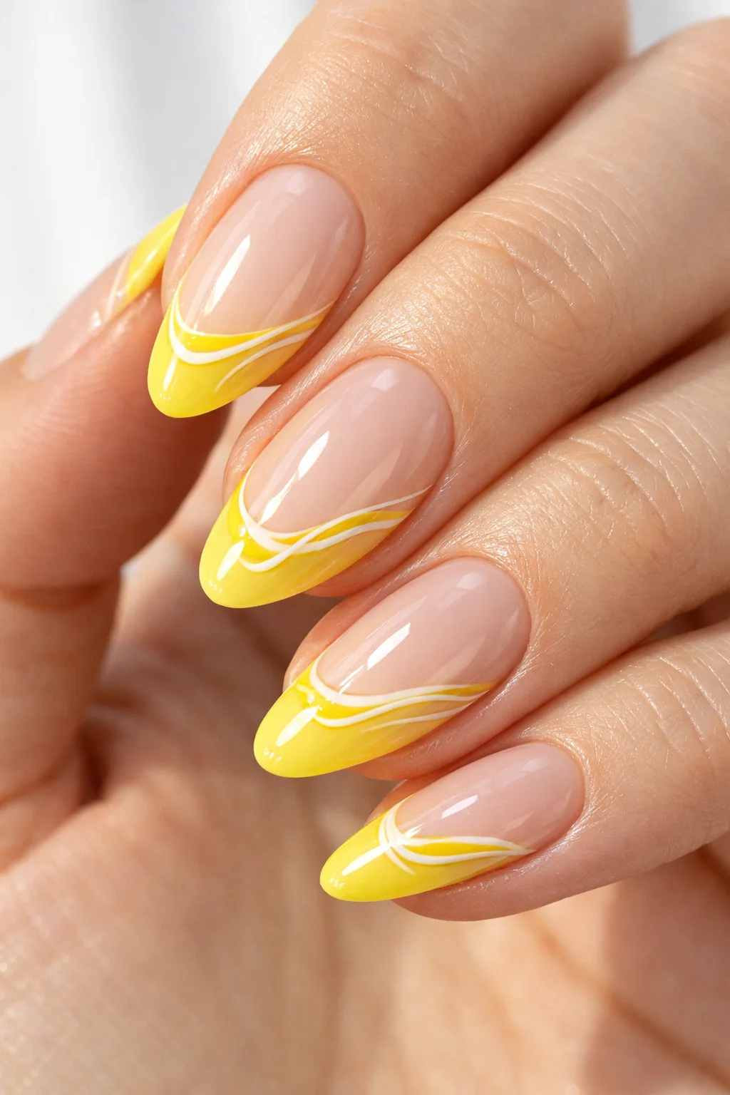 Nude nails with yellow French tips and white swirl nail art bright sunny summer manicure design