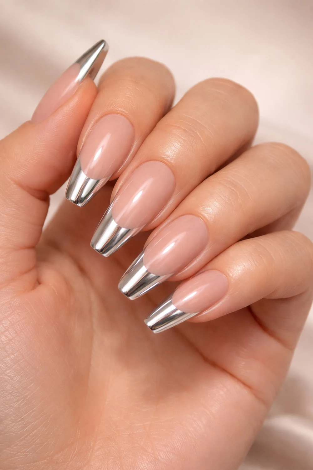 Chrome french tip acrylic nails with nude base and metallic silver tips creating a modern elegant manicure perfect for trendy nail inspiration.