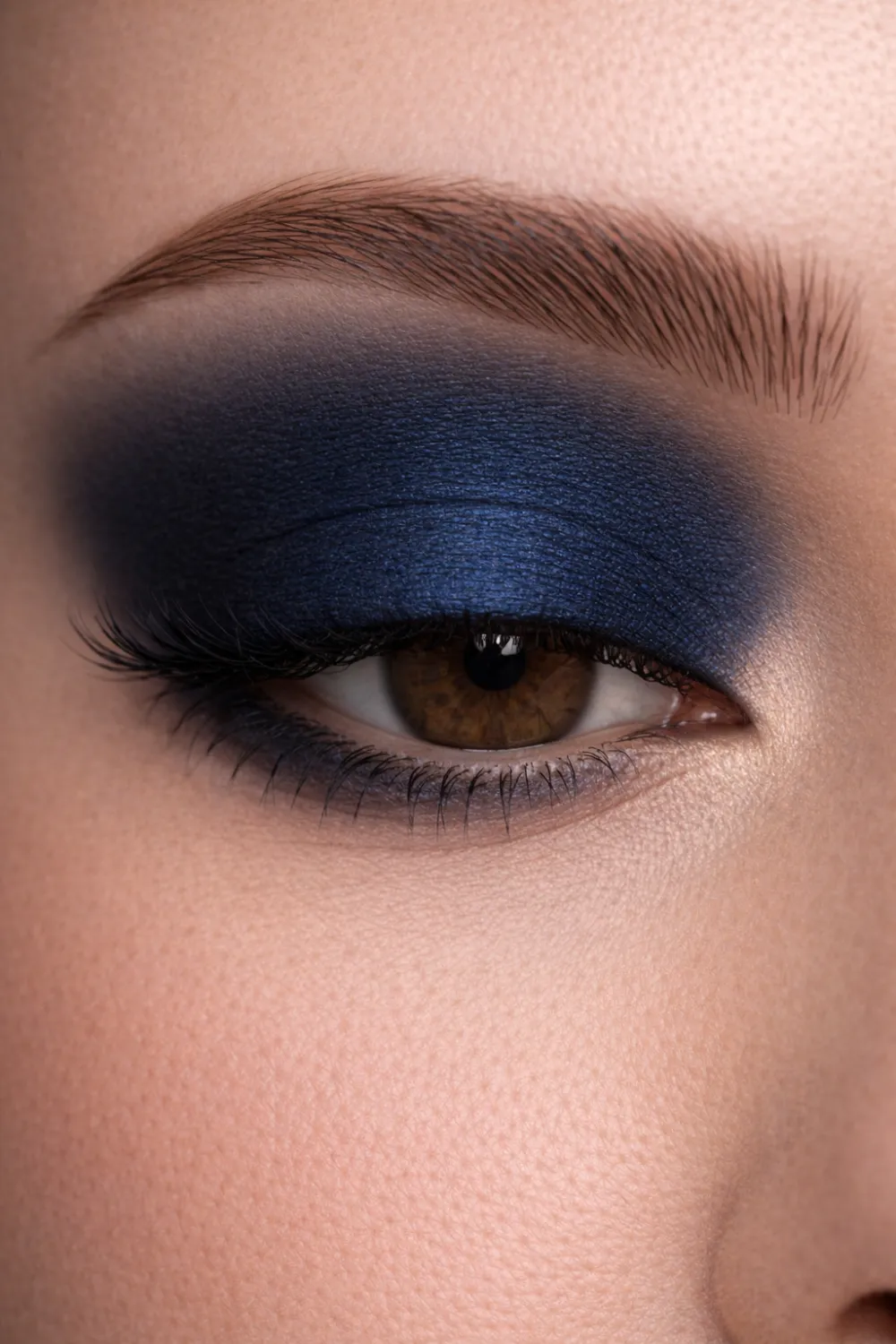 Navy blue smokey eyeshadow look for brown eyes close up with deep blue lid blended dramatic glam eye makeup inspiration