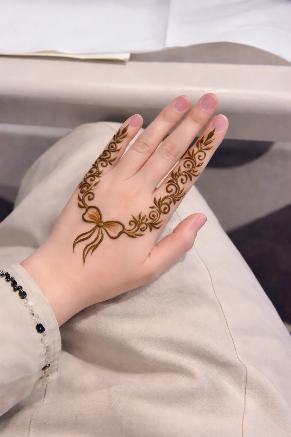bow style mehndi design with leafy swirls on fingers minimal elegant henna pattern modern mehndi inspiration
