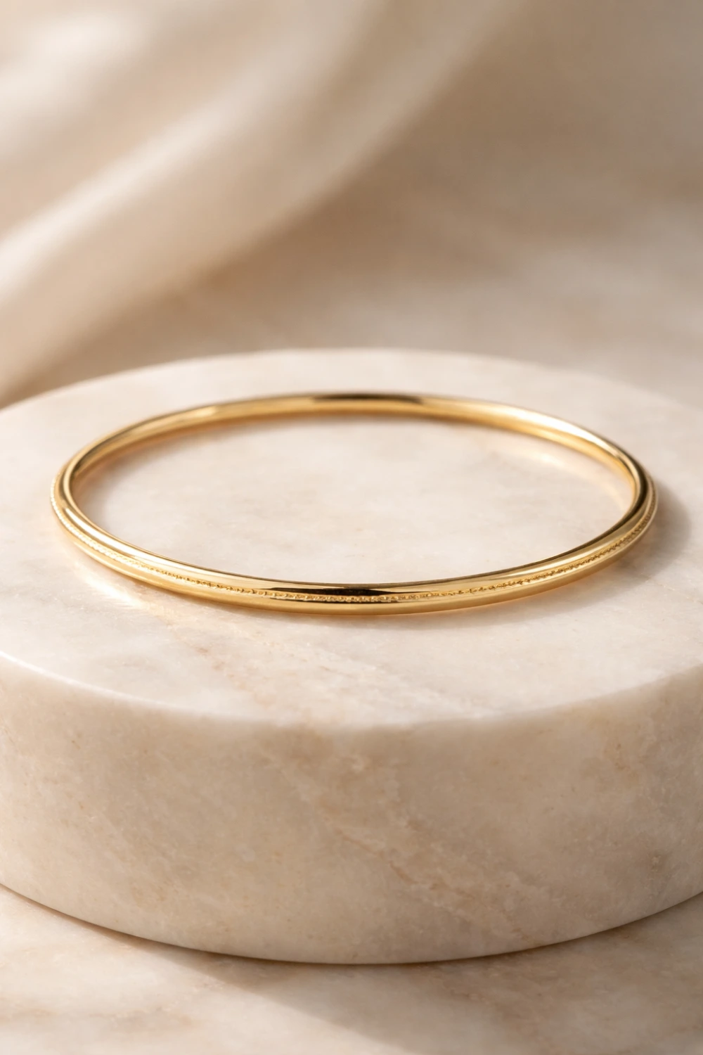 classic gold bangle bracelet polished elegant gold bracelet for women timeless luxury jewelry displayed on marble pedestal old money aesthetic