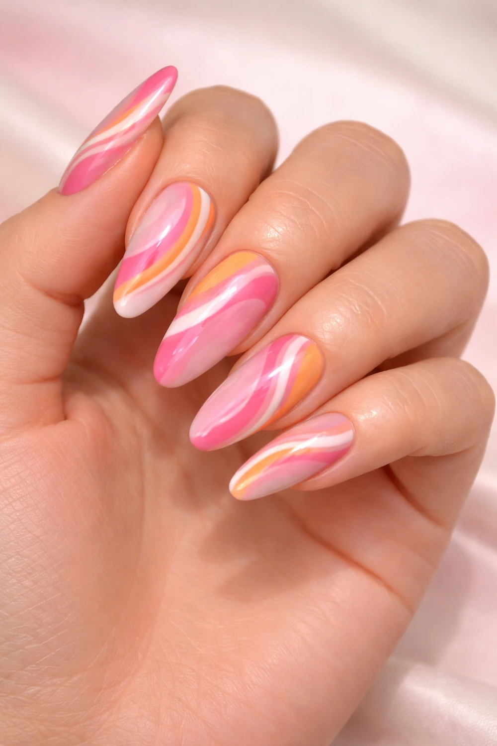 Pink swirl acrylic nails featuring flowing abstract lines in pink, white and peach creating a playful modern manicure perfect for trendy summer nail inspiration.