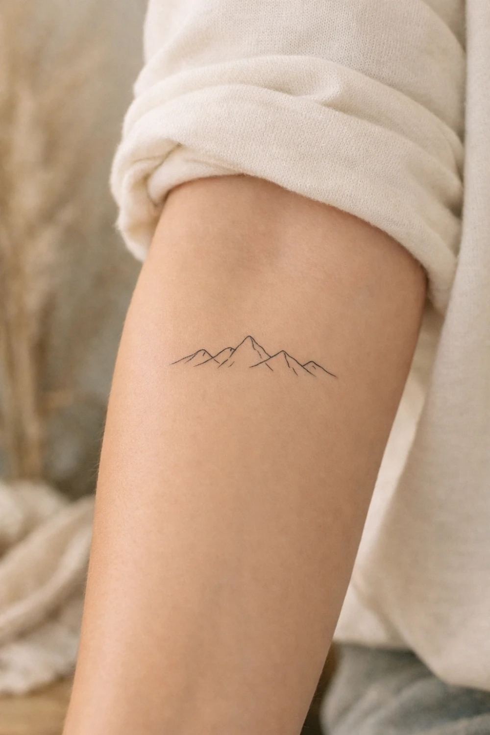 minimal mountain tattoo with simple line art peaks, small nature tattoo design symbolizing strength adventure resilience and love for travel and outdoor life