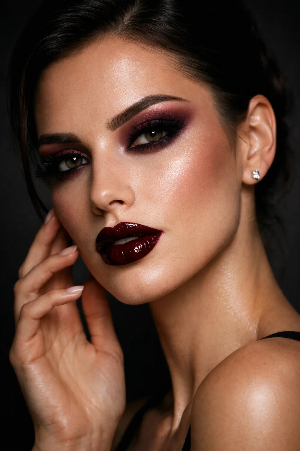 Dark cherry lipstick glam makeup look with burgundy smokey eyes and glowing highlighted skin creating a bold dramatic beauty style perfect for night makeup inspiration