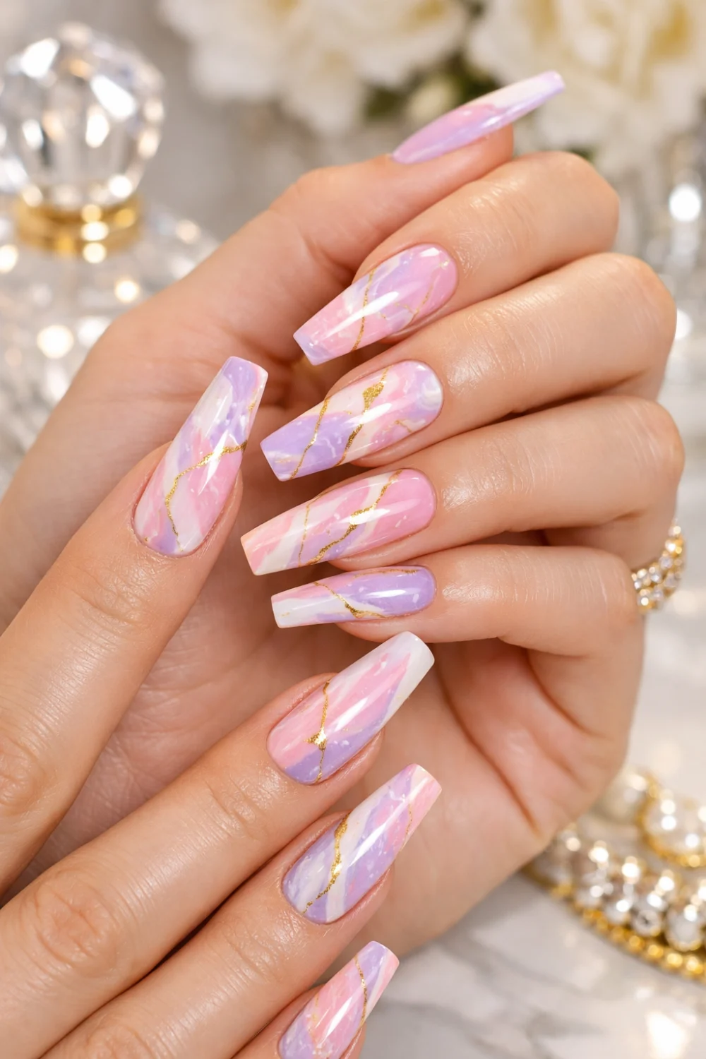 Long coffin nails with pastel marble design in pink, white, and lavender with gold vein accents on elegant hands, glossy finish, luxury nail style