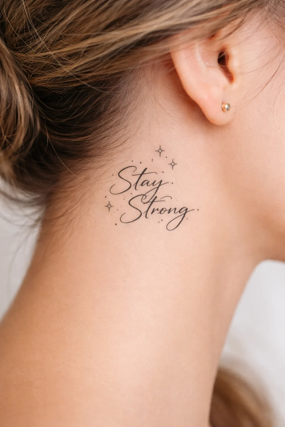 Stay Strong neck script tattoo for women with small star accents symbolizing resilience courage and positivity, inspirational neck tattoo trending on Pinterest.