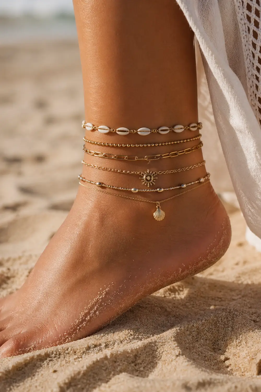 layered gold anklet stack with shells charms beads on beach ankle boho style multiple anklets summer aesthetic close up
