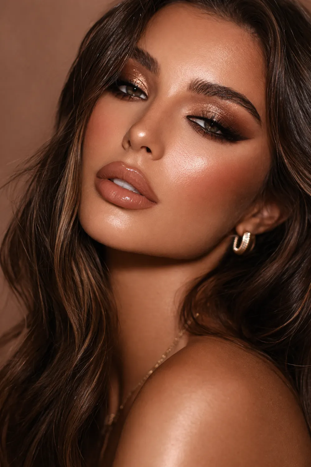 Glam bronze latte makeup look featuring deep bronze smokey eyeshadow glowing bronzed skin and nude lips creating a bold warm glam beauty aesthetic trending on Pinterest makeup inspiration.