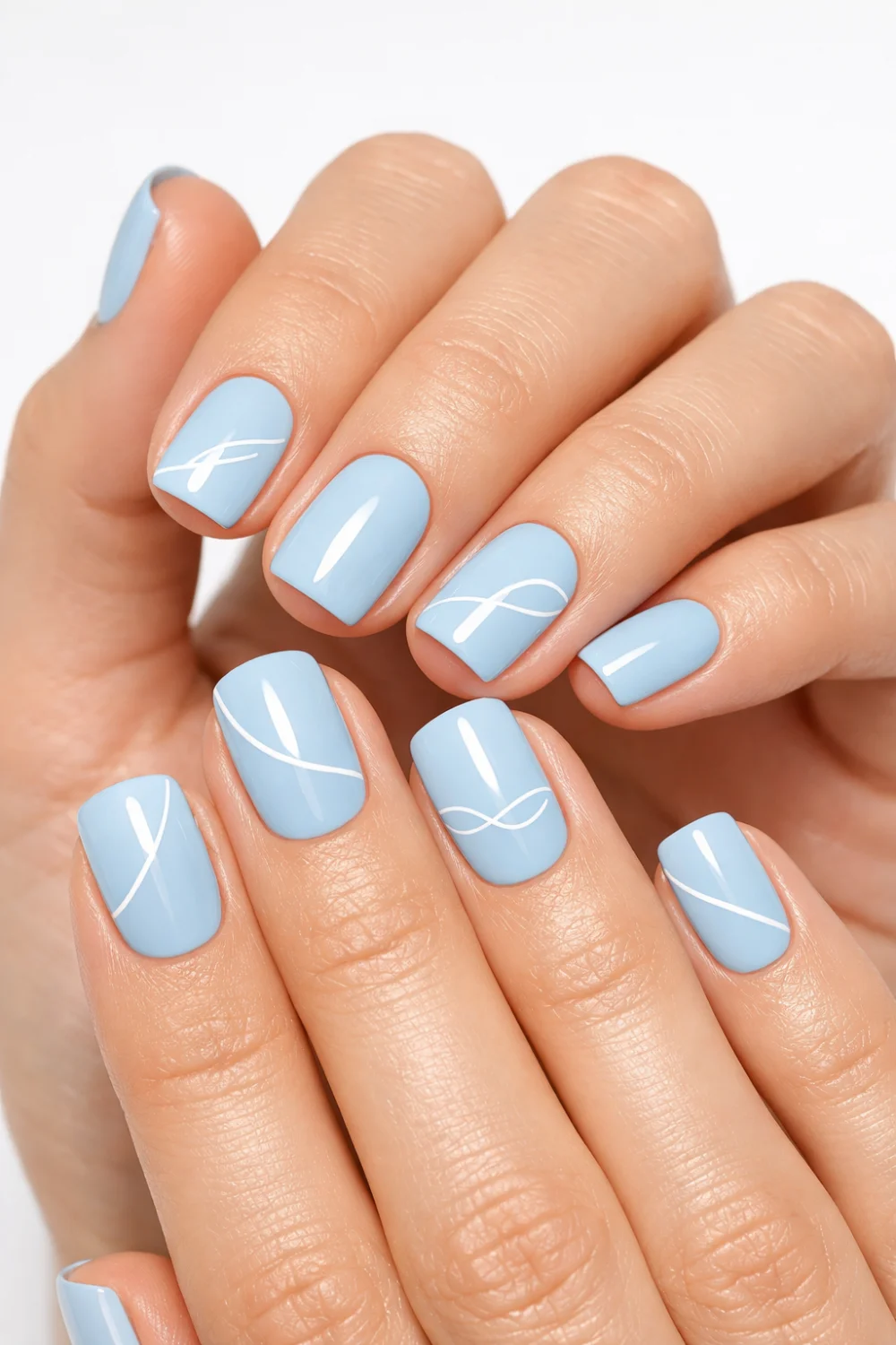 Short square baby blue nails with thin white minimalist line art on slim feminine hands, glossy finish, clean studio background, modern pastel nail design