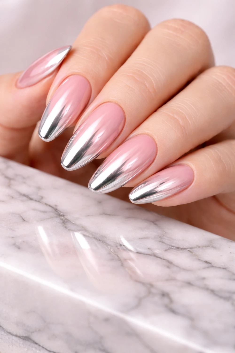 Chrome ombre nails with pink nude base fading into silver metallic tips, glossy gradient chrome manicure reflecting light, trendy chrome ombre nail design inspiration