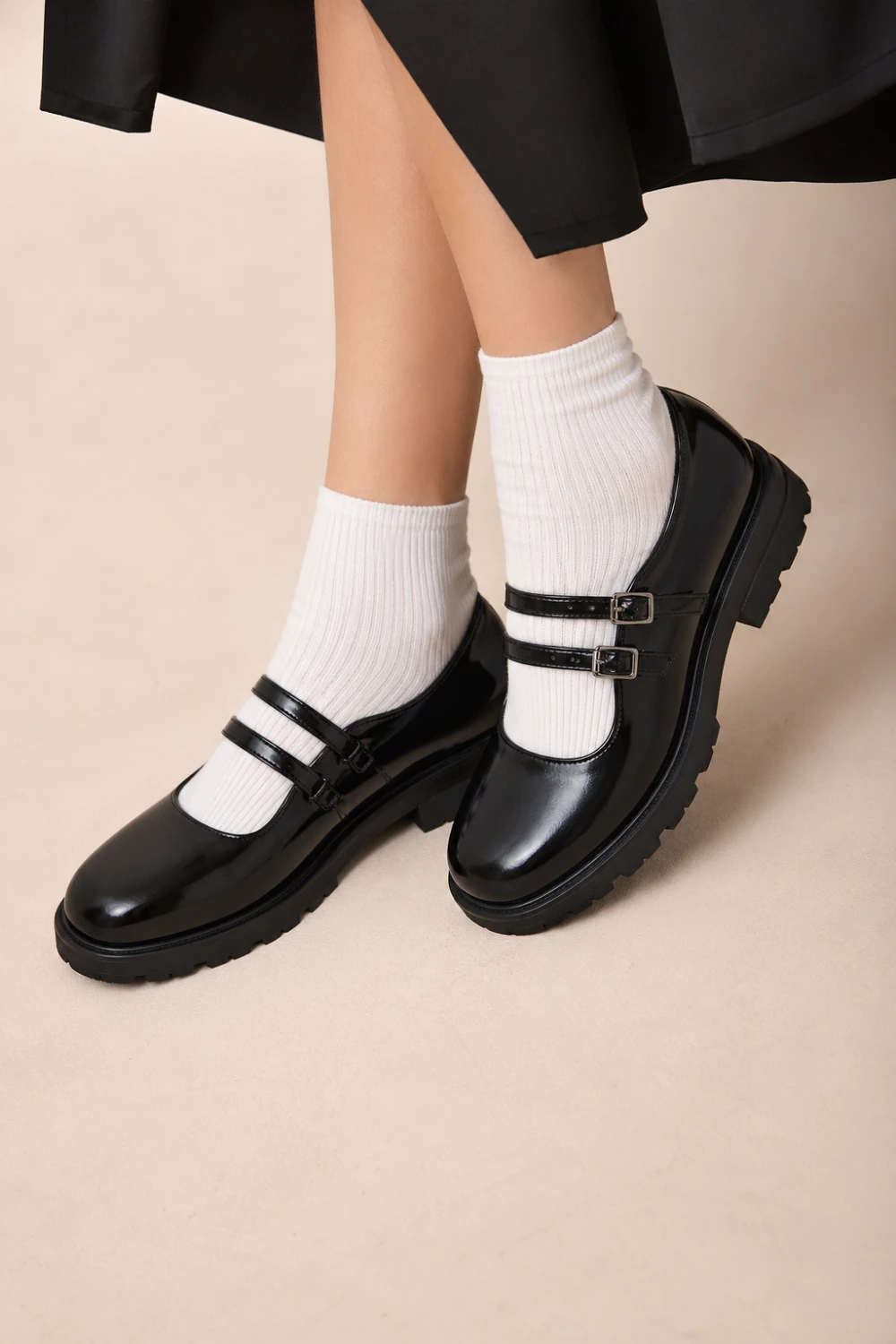 Black chunky mary jane flats with double straps and thick sole worn with white socks, modern edgy footwear style, bold minimalist fashion, perfect for statement casual outfits and street style looks