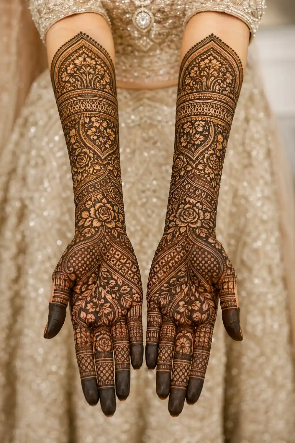 symmetrical bridal full sleeve mehndi design on both hands with mirrored floral and paisley patterns, dense detailed henna, dark fingertips, traditional full coverage mehndi from fingers to elbow