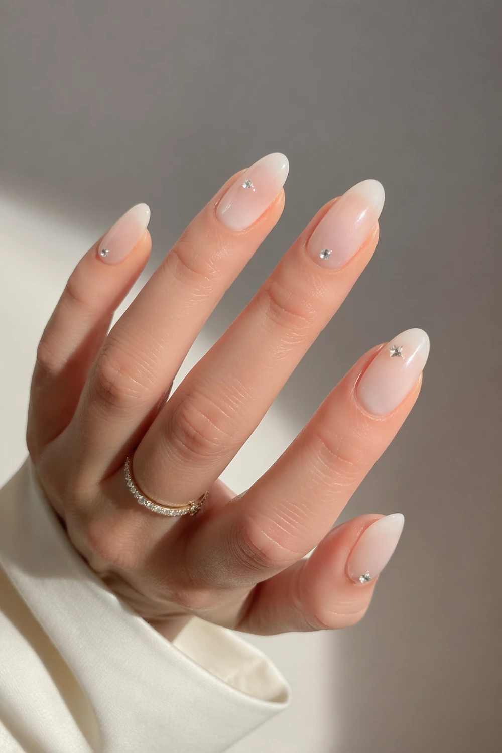 milk bath nails with crystals small rhinestone accents glossy milky base almond shape nails soft glam manicure elegant minimal nail design