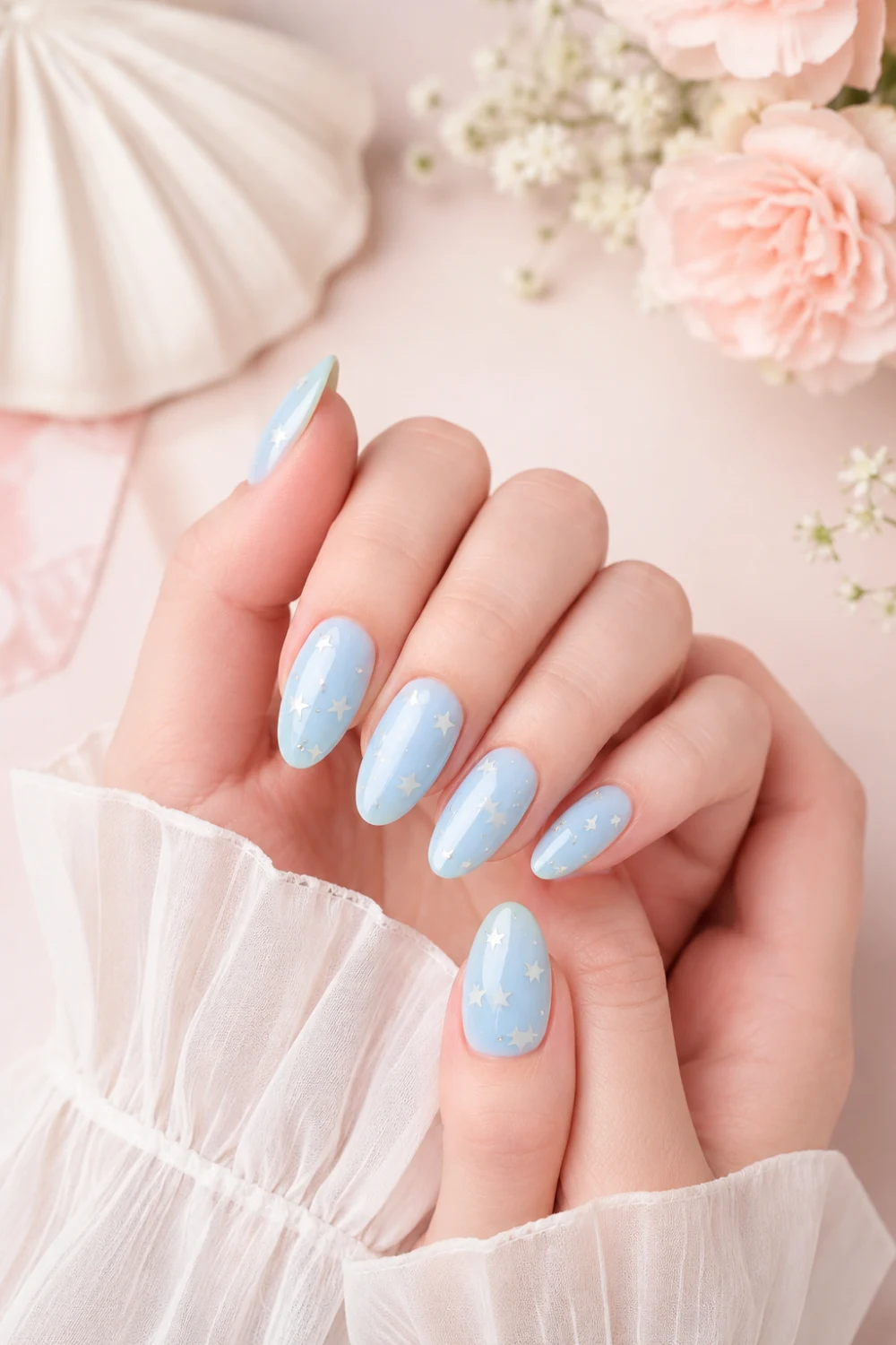 Ultra glossy baby blue almond nails featuring delicate white star nail art with soft feminine aesthetics, elegant pastel manicure design, clean Pinterest-inspired nail look with dreamy spring vibes and luxury beauty styling.