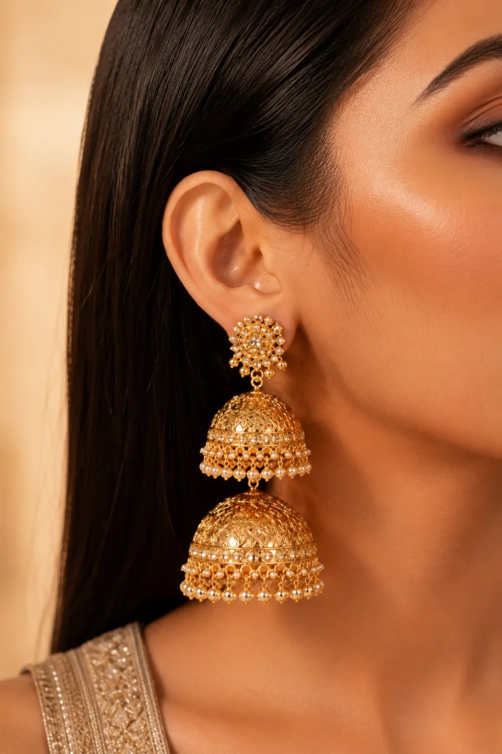 Double dome gold jhumka earrings with layered dome structure, intricate gold detailing, pearl accents, and luxurious festive ethnic fashion styling on female model