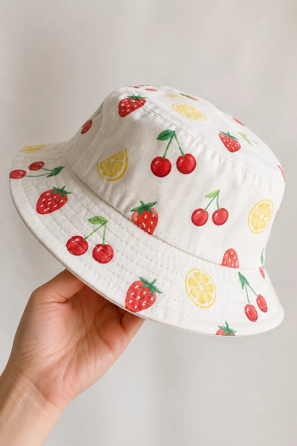 White hand painted bucket hat with strawberries cherries and lemon pattern, cute colorful DIY painted hat