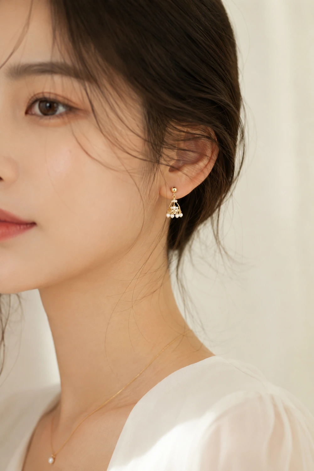 Tiny Korean inspired gold jhumka earrings with delicate pearl accents, minimalist luxury styling, soft feminine fashion aesthetic, and elegant everyday jewelry look
