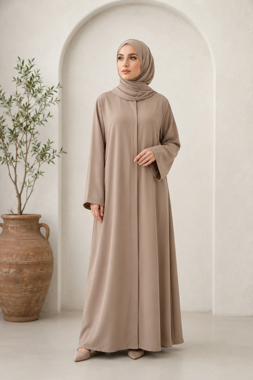 Elegant Muslim woman wearing Turkish minimalist beige abaya with matching hijab and soft neutral modest fashion styling full body portrait