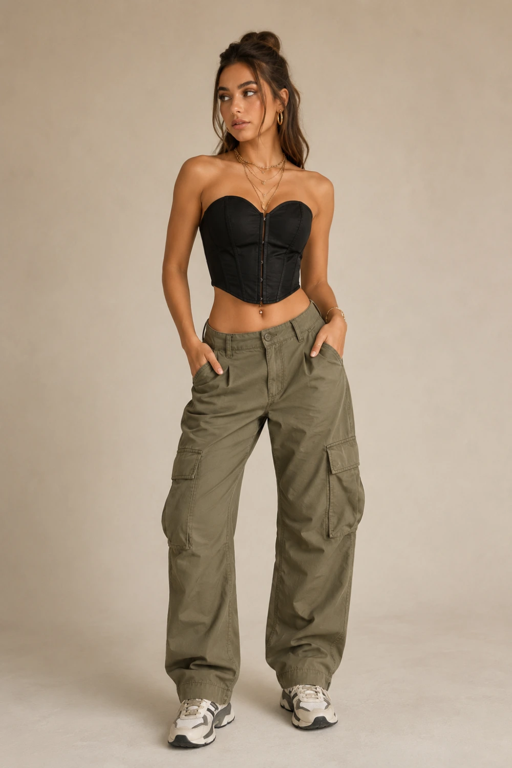 Trendy woman wearing black corset top with olive cargo pants and chunky sneakers, edgy casual night out outfit idea, modern street-style women’s fashion aesthetic with layered gold jewelry.