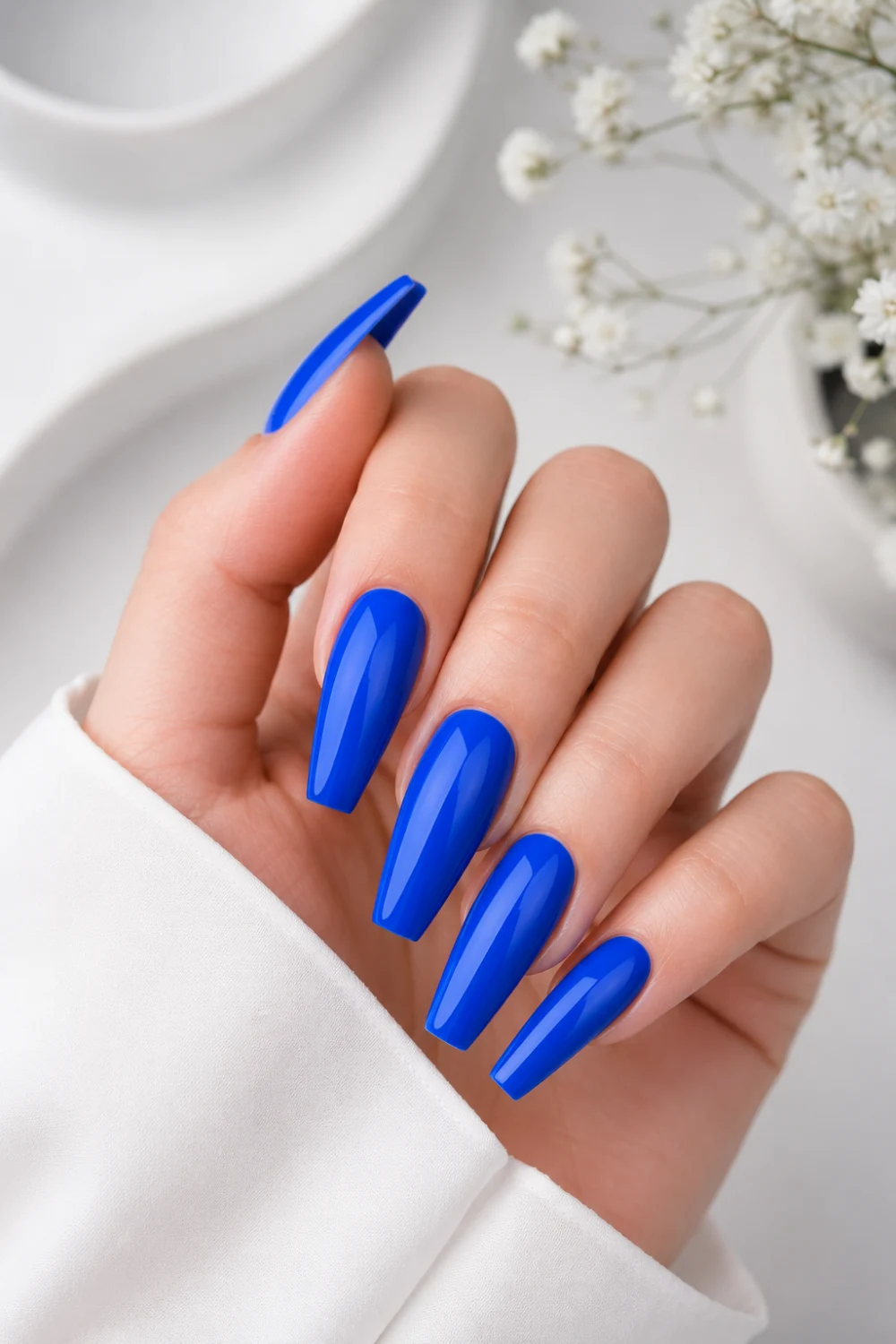 Bright electric blue coffin nails with ultra glossy finish, bold statement manicure design, trendy royal blue acrylic nails with modern glam Pinterest-inspired beauty aesthetic.