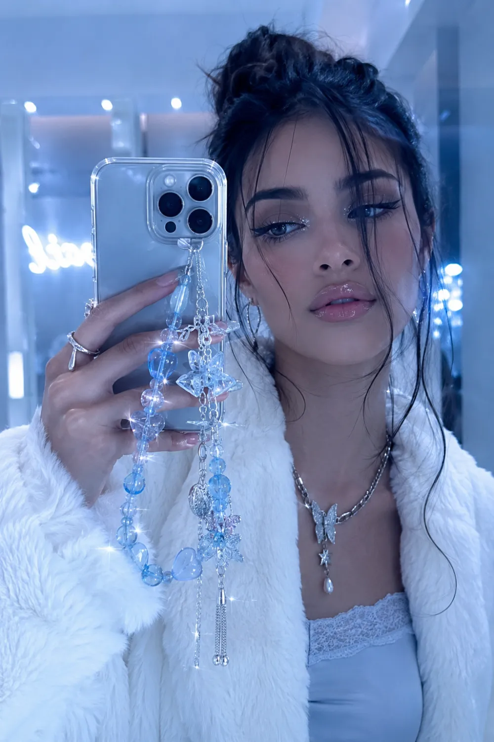 Trendy ice blue crystal phone charm with translucent blue beads, silver chains, and sparkling star charms styled with soft glam fashion aesthetics for viral 2026 accessory trends.