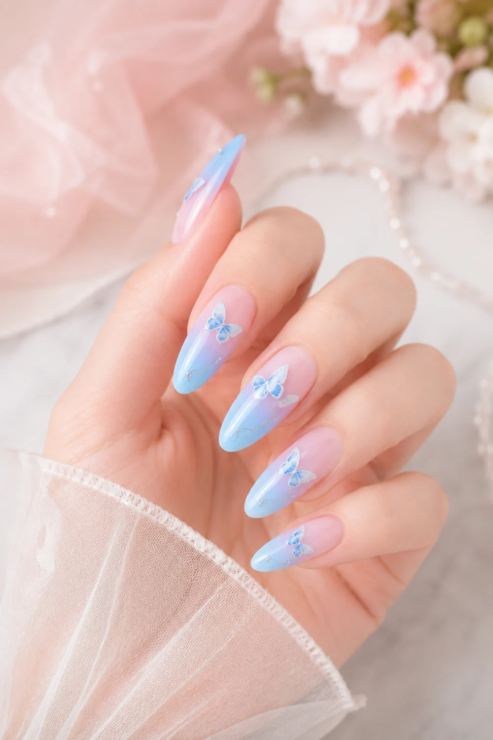 Pastel blue butterfly ombre almond nails with glossy finish, dreamy feminine nail art featuring delicate butterfly accents and soft Pinterest-inspired glam aesthetic.