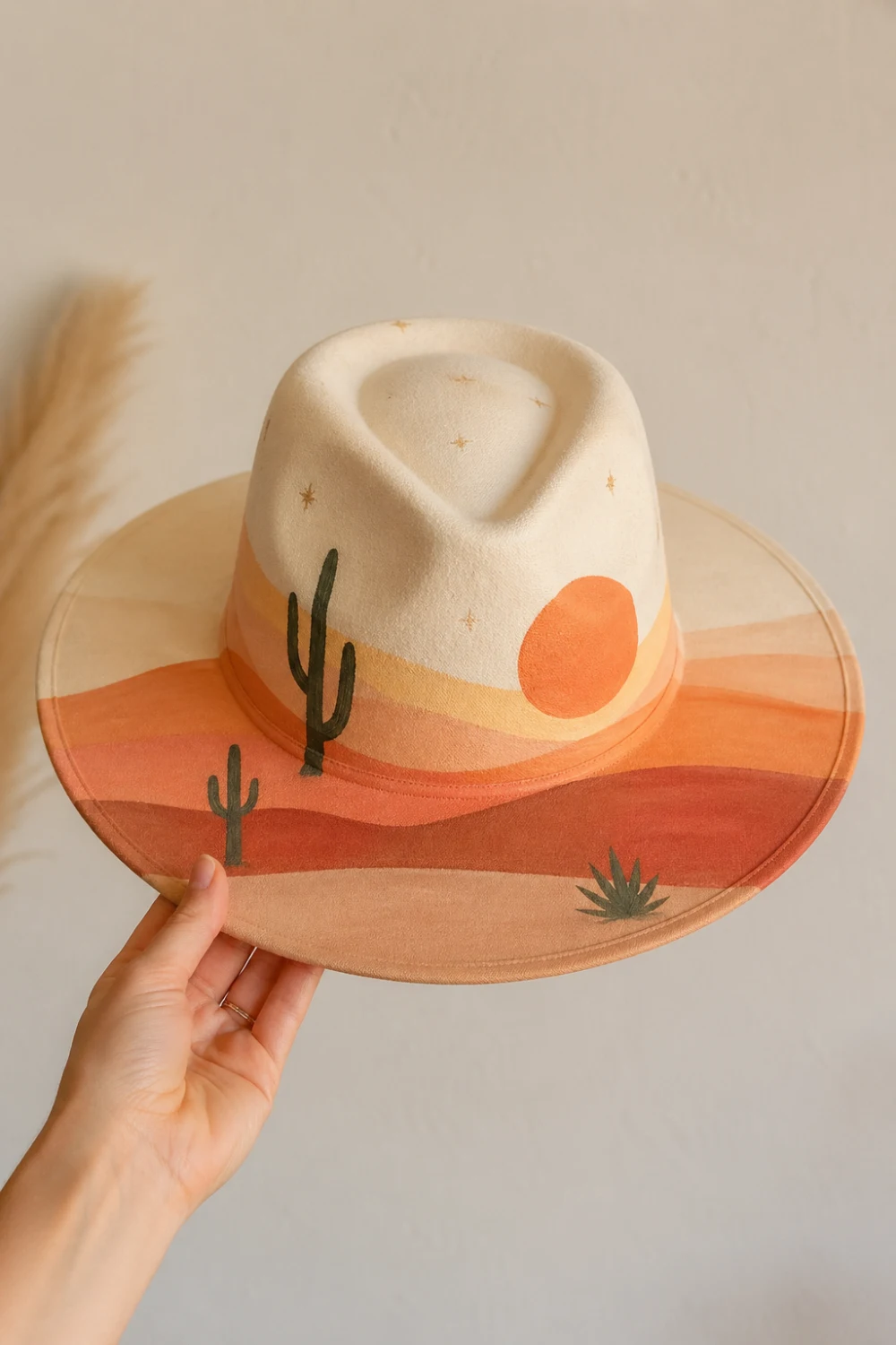 Beige hand painted hat with desert sunset gradient and cactus silhouettes, warm tones aesthetic DIY hat design