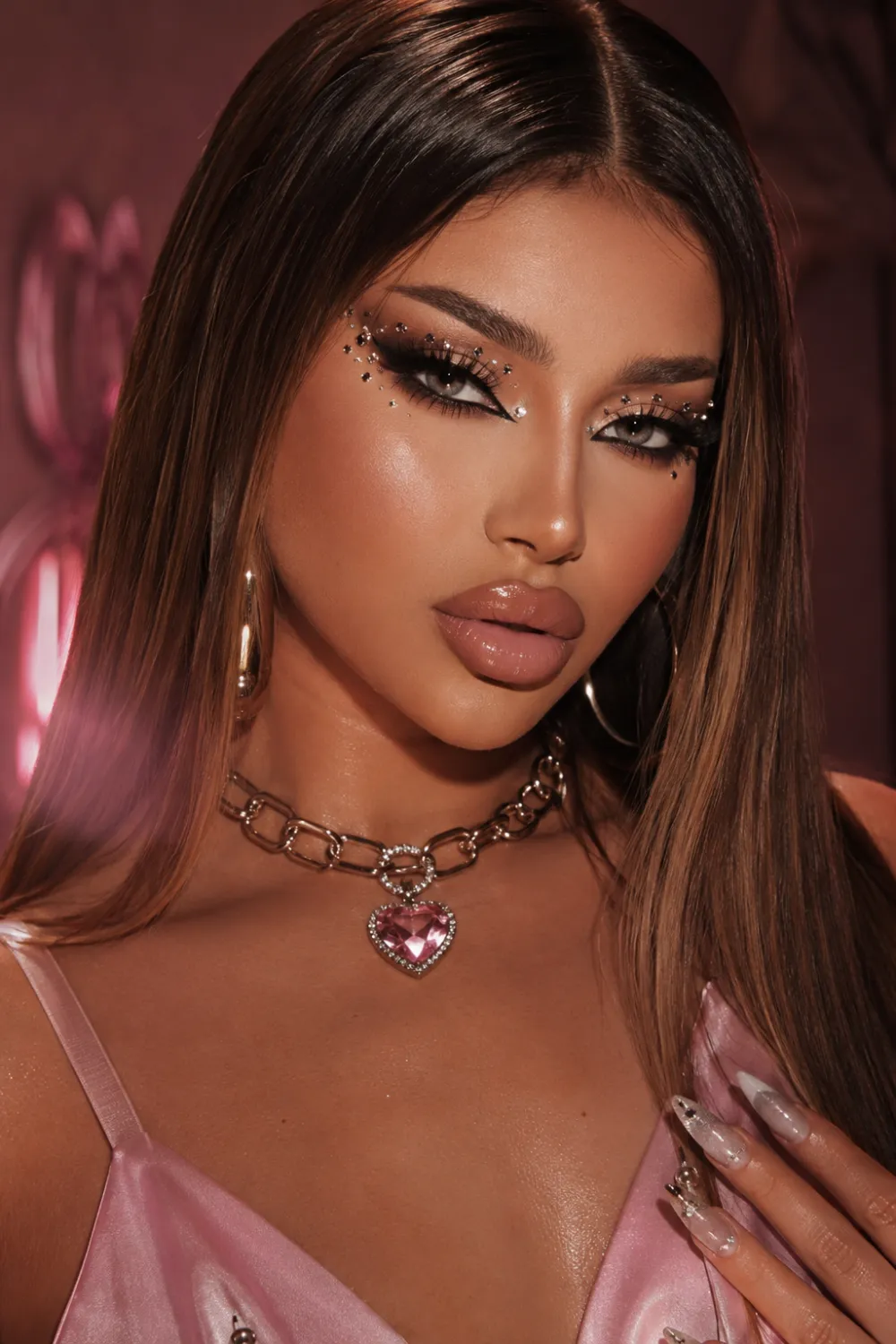 Bratz doll inspired Y2K makeup with dramatic eyeliner, glossy overlined lips, rhinestone eye details, bronzed glowing skin, sleek straight hair, and glamorous early-2000s beauty aesthetics.