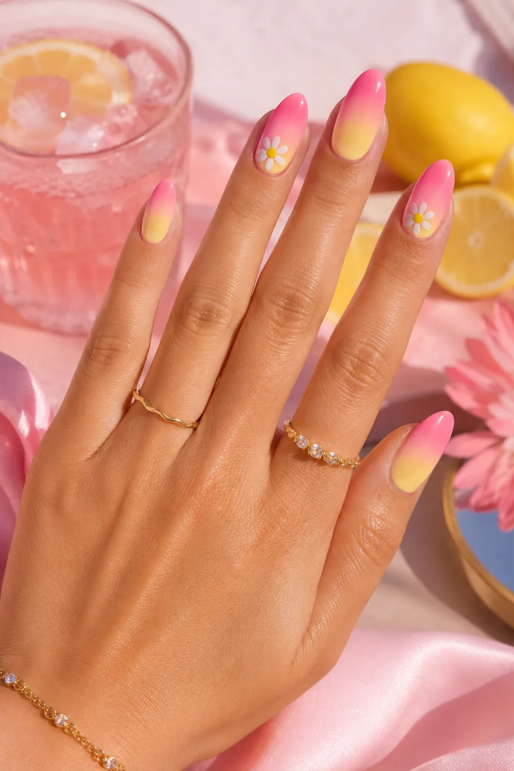 Pink lemonade ombre nails with glossy pink and yellow gradient, daisy nail art details, almond-shaped nails, and bright summer manicure styling perfect for 2026 Pinterest trends.