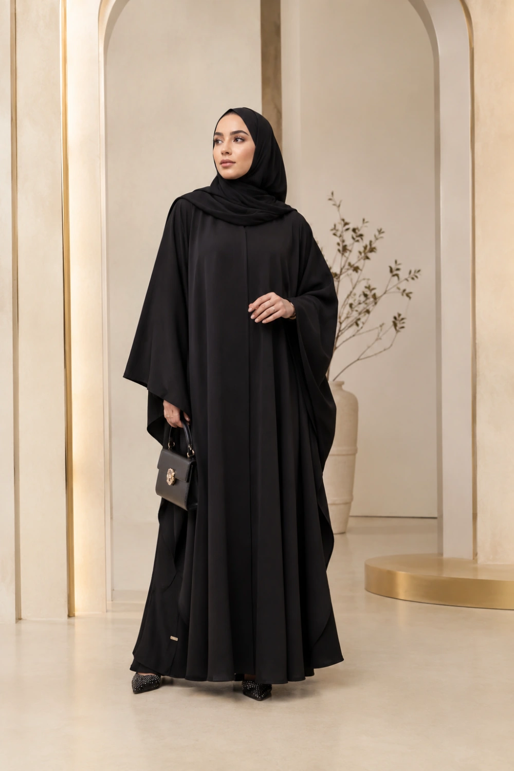 Muslim woman wearing elegant black butterfly abaya with loose flowing sleeves and matching hijab full body luxury modest fashion photography