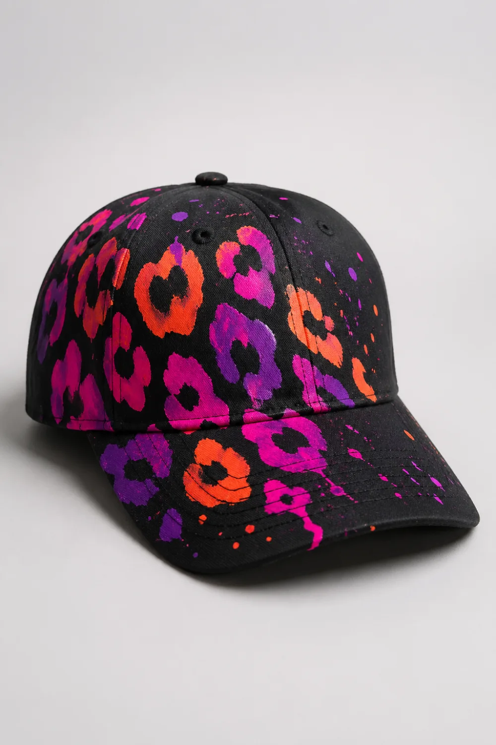 Black hand painted cap with neon leopard print in pink orange and purple, bold streetwear DIY painted cap design