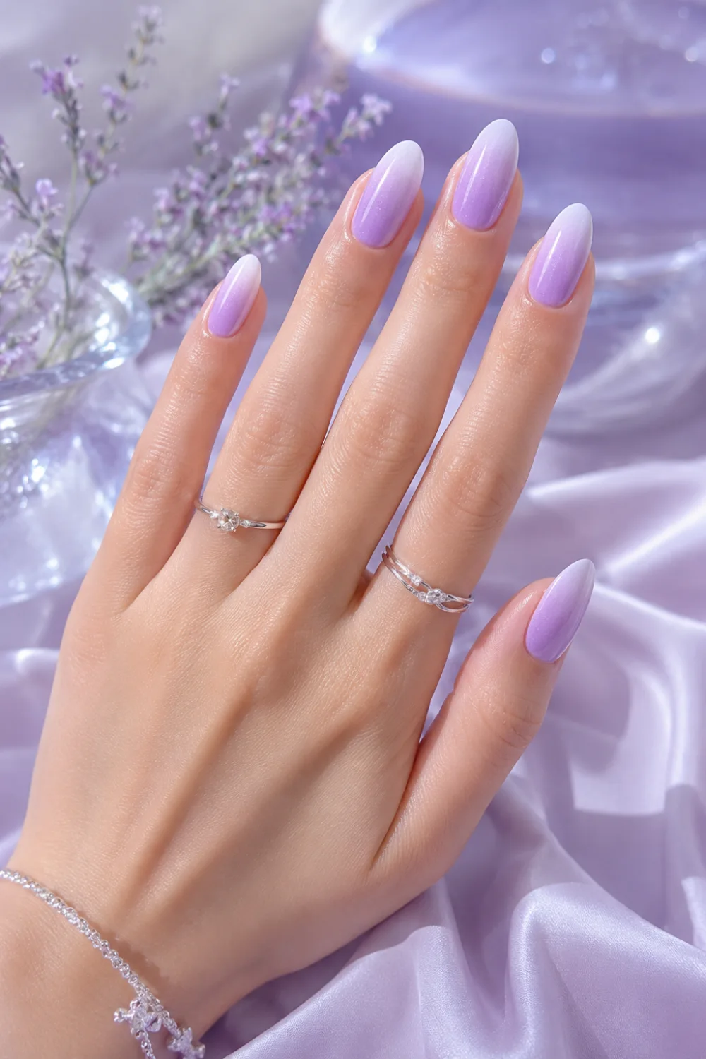 Lavender ice ombre nails with pastel lilac and white glossy gradient on almond-shaped nails, featuring soft feminine styling and dreamy summer manicure inspiration for 2026.