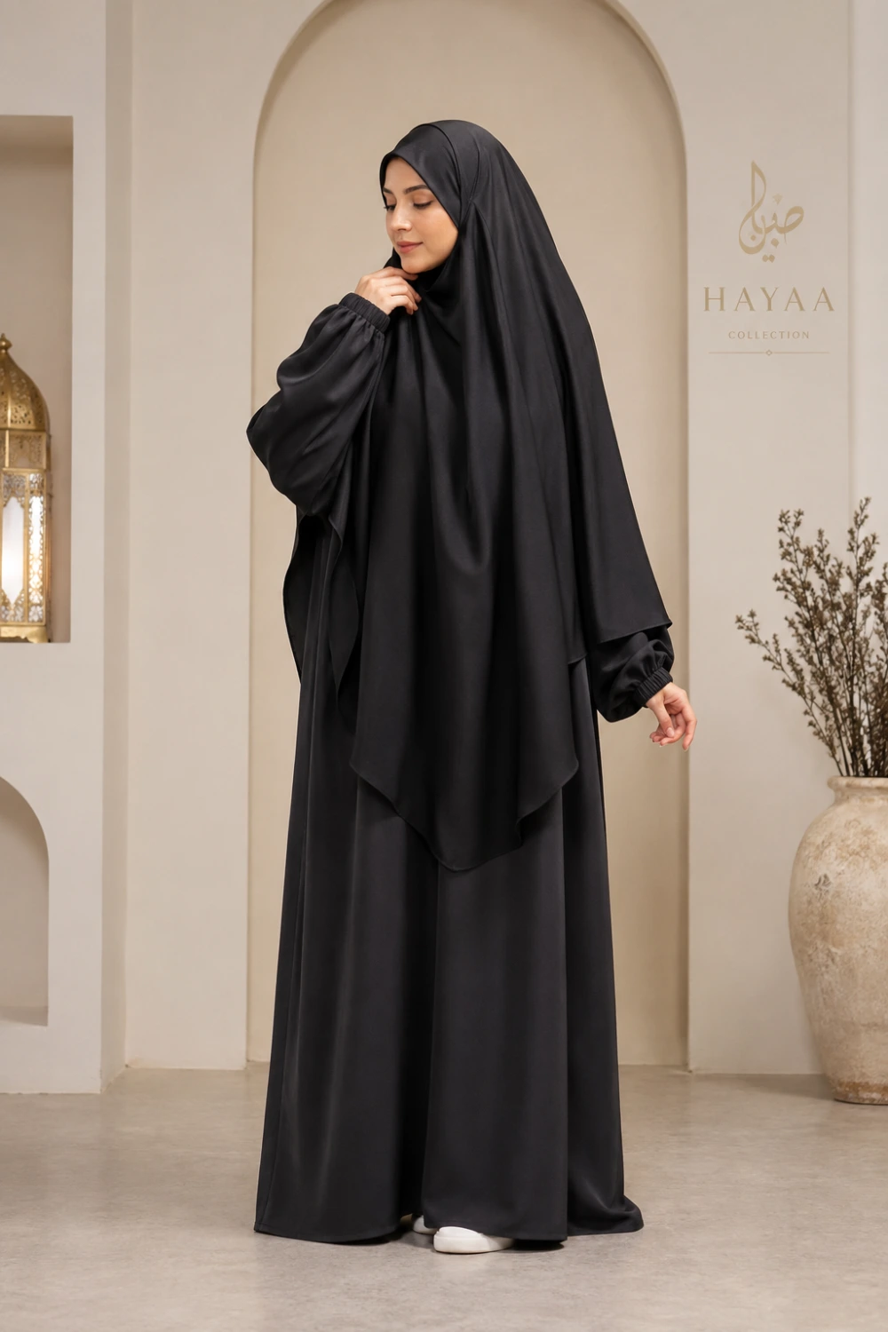 Elegant Muslim woman wearing black khimar abaya set with layered modest silhouette and matching hijab full body indoor fashion photography
