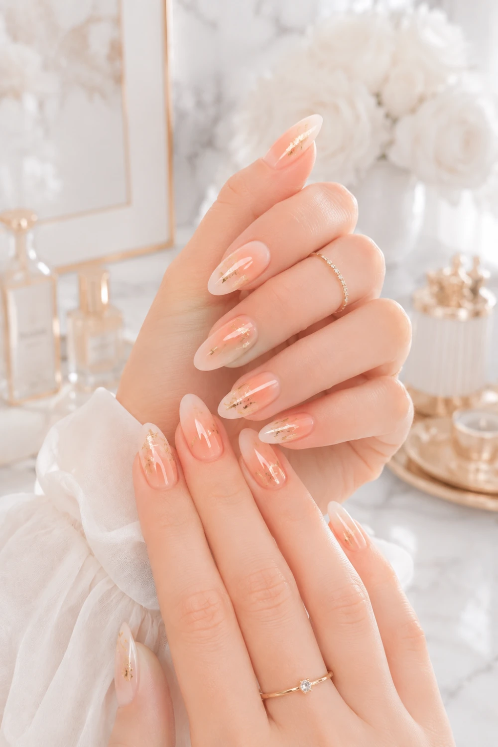 Peach gold foil nails with glossy almond manicure, luxury feminine hands, marble background, and elegant gold nail art details