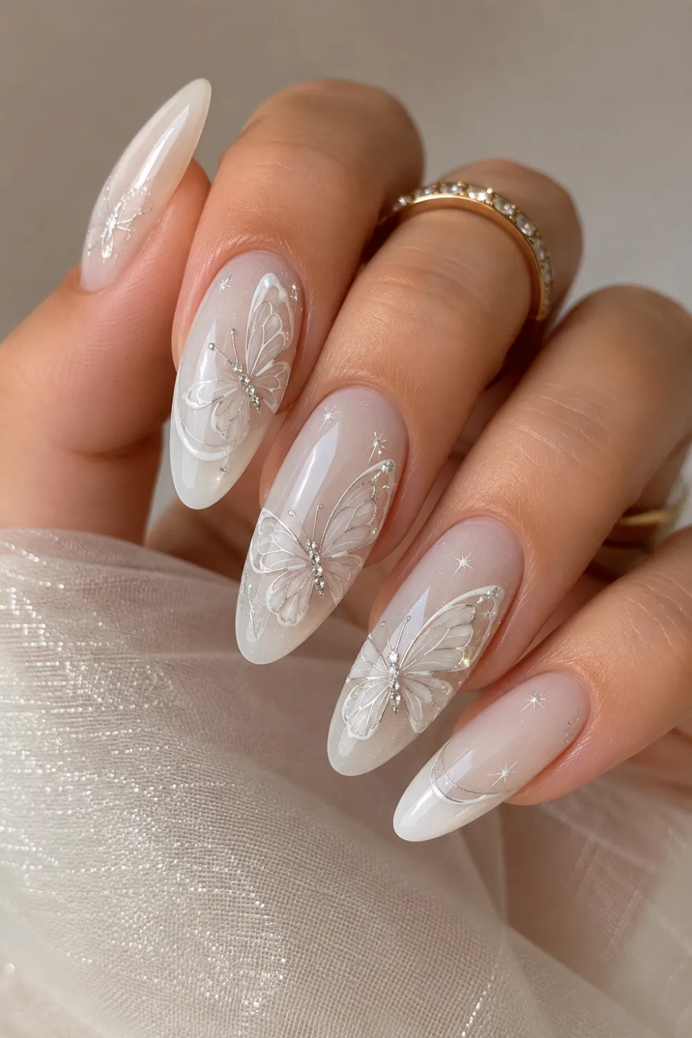 Milky white glossy almond nails with delicate butterfly wing nail art, elegant feminine manicure design, soft glam nails, and classy salon-style finish.