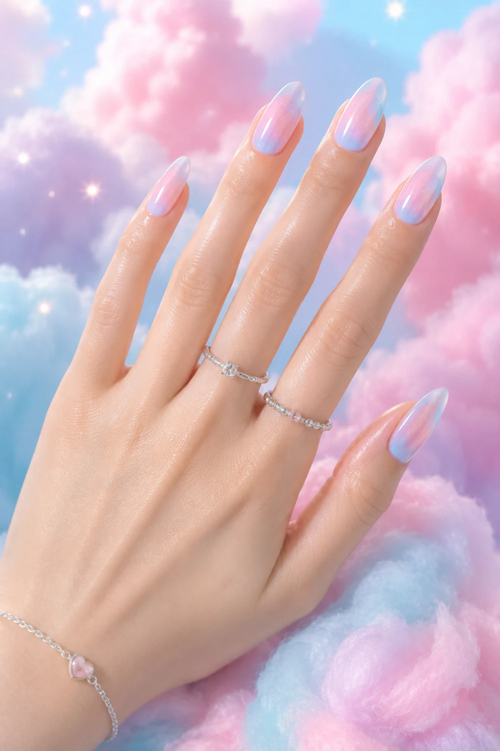 Cotton candy ombre nails with pastel pink and baby blue glossy gradient on almond-shaped nails, featuring dreamy cloud-inspired manicure styling and trendy summer nail inspiration for 2026.