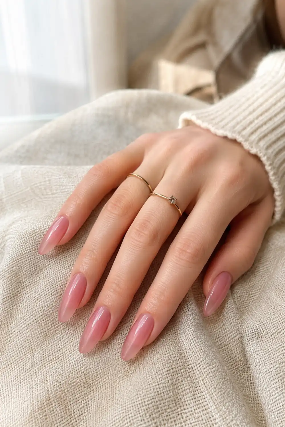 Close-up of pink jelly glass almond nails featuring a glossy translucent gel finish, soft blush pink color, elegant almond shape, and a clean Korean-inspired manicure perfect for a chic everyday look.