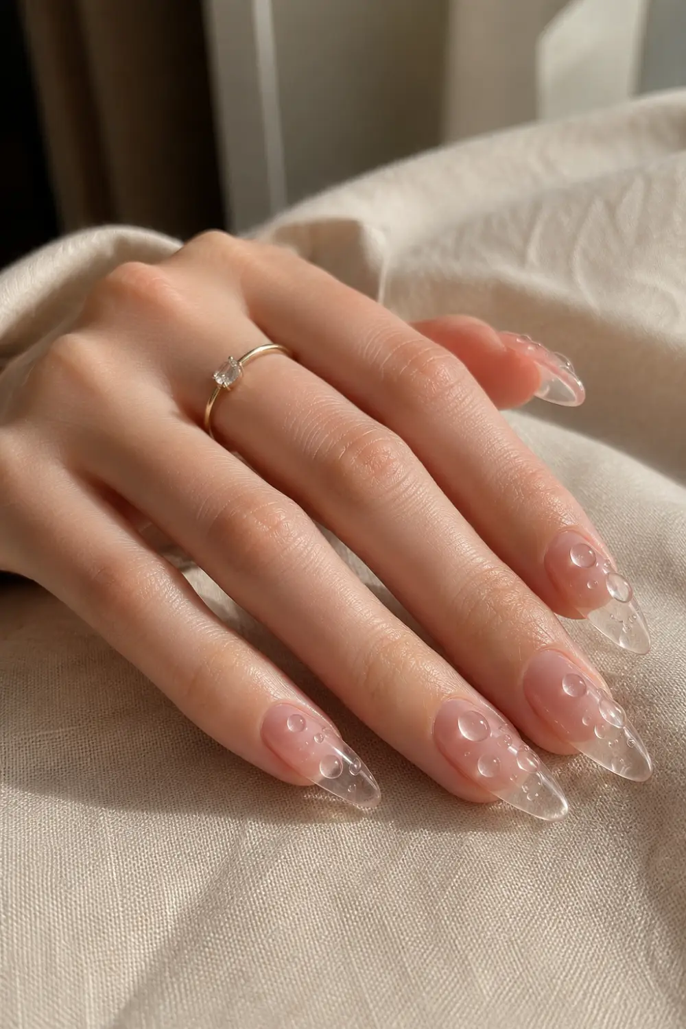 Crystal water drop jelly almond nails with realistic 3D droplet details, transparent gel tips, glossy finish, and modern glass-inspired nail art design.