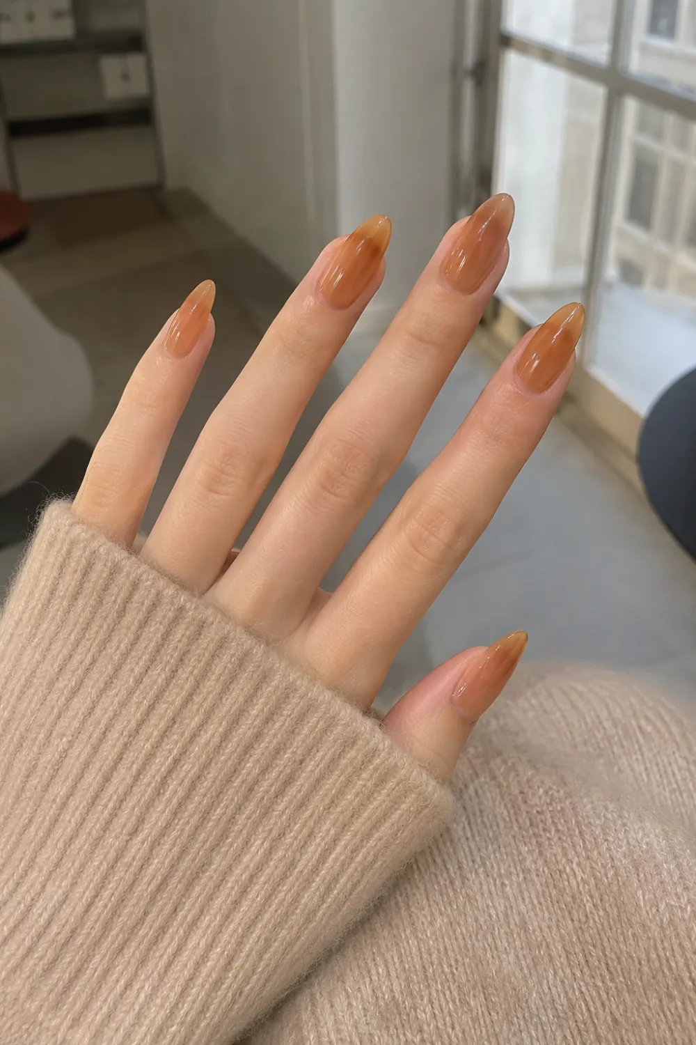 Caramel jelly almond nails with warm brown translucent gel polish, glossy finish, almond shape, and a chic neutral manicure perfect for every season.
