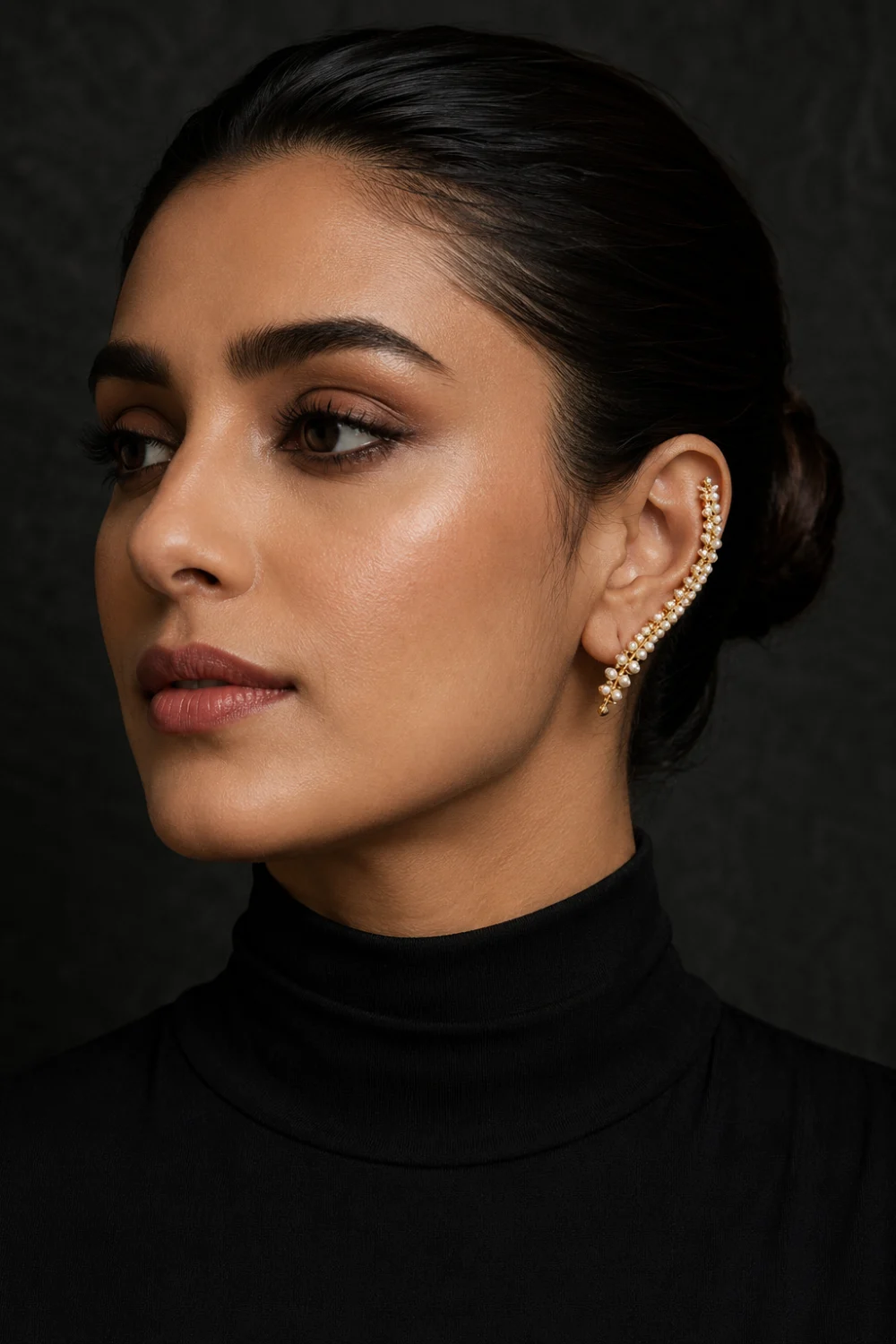 Close up beauty portrait featuring a woman wearing a pearl ear cuff decorated with tiny freshwater pearls and elegant modern jewelry styling.